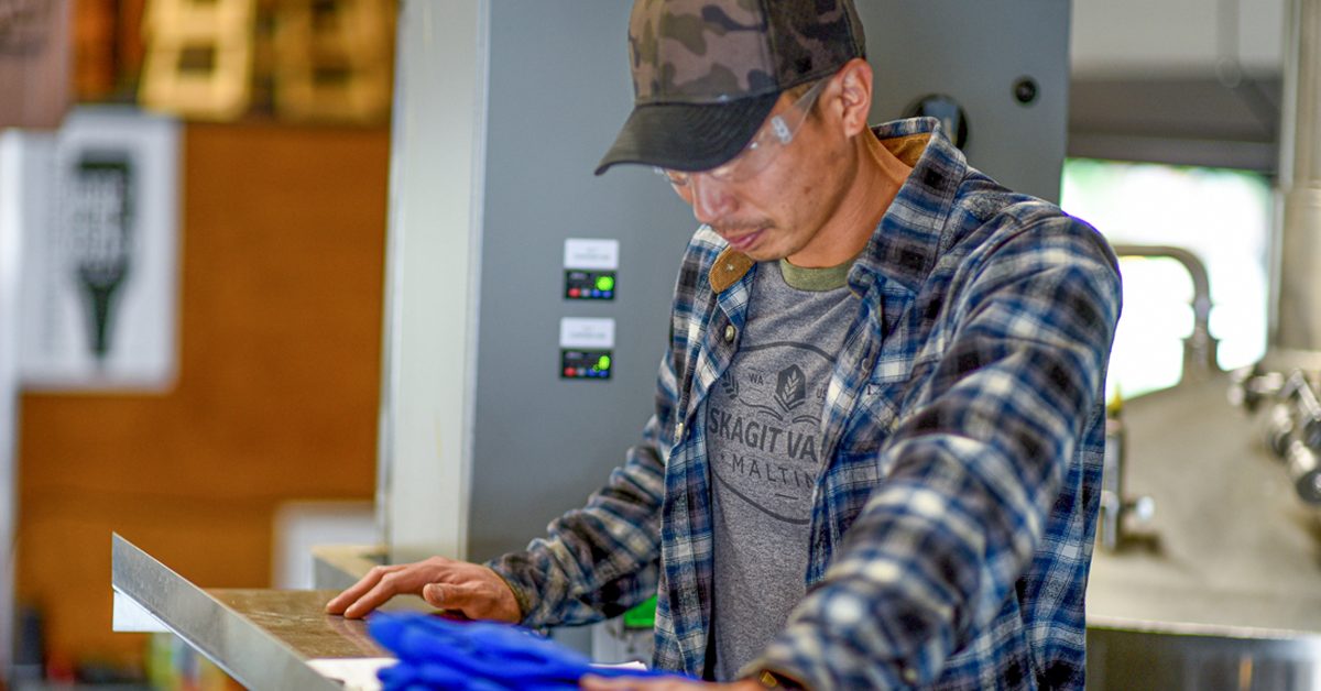 man reading paperwork in brewery