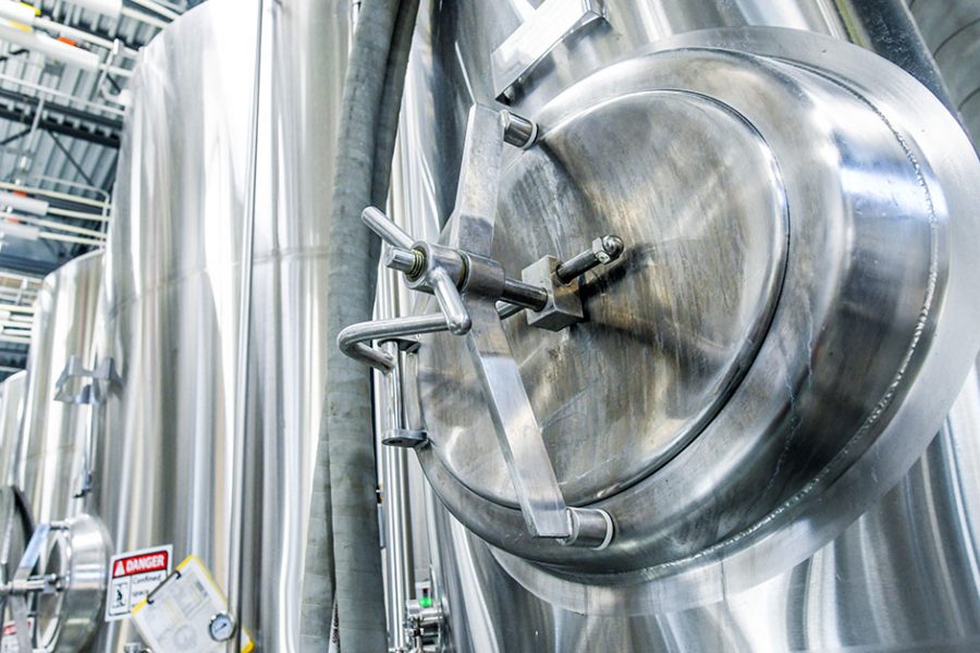 row of fermenters in craft brewery 1200x628 1